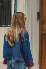Campera de jean corte boxy con cierre frontal, cuello camisero y bolsillos frontales con solapa en tejido de punto color vino. Presenta detalles bordados en los bolsillos.