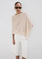 Poncho de punto con diseño de capa, asimétrico, cuello barco y manga tres cuartos.