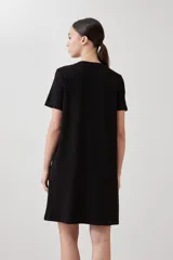 Vestido midi negro de corte recto, con cuello redondo y botones frontales.