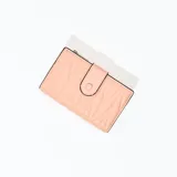 Billetera pequeña color rosa con diseño acolchado en forma de rombos y cierre con broche a presión.