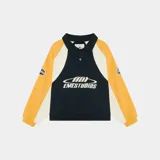 Polo de manga larga Eme Studios con diseño racing, confeccionado en algodón pesado. Presenta cuello tipo polo con cierre de botones, mangas raglán y paneles en colores amarillo, blanco y azul. Incluye logo bordado en el frente y detalles gráficos en las mangas.