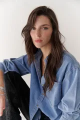 Camisa de jean celeste de manga larga con botones frontales y en los puños.