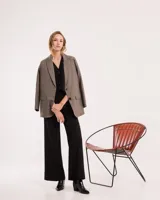 Chaleco de vestir gris oscuro con textura tipo tweed, escote en V y botones frontales. Corte levemente entallado y largo a la cintura.