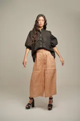 Blusa de lino color negro, con cuello mao, cierre frontal con botones y mangas abullonadas con puños ajustados con detalle de tablas.