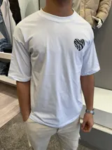 Remera blanca de corte oversize con estampa en la espalda de un corazón con diseño de cebra y la frase 'very good' en la parte inferior.
