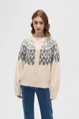 Cardigan de tejido jacquard con diseño geométrico en la parte superior, cuello redondo y cierre frontal con botones. Presenta un corte holgado y mangas largas con puños acanalados.