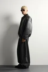 Cazadora acolchada relaxed fit de efecto piel en color negro, con cuello camisero, cierre frontal de cremallera metálica, bolsillos frontales de vivo y puños elásticos.