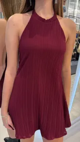 Vestido corto bordó con diseño plisado, escote halter y silueta fluida.