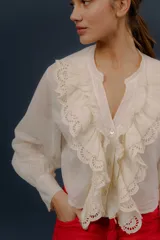 Camisa verde de manga larga, con volados frontales y detalles de puntilla bordada.