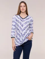 Remera confeccionada en algodón liviano de silueta semi entallada, con escote en V y mangas tres cuartos. Presenta un diseño estampado que combina franjas florales en tonos violeta y rayas chevron, con un nudo decorativo en el ruedo frontal.
