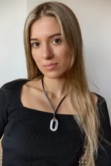 Collar con tiento negro y dije de piedra natural ovalada en tonos grises y azules.