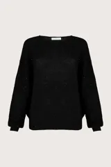 Suéter de cuello redondo en color negro, con ribete en los puños. Diseño holgado con tejido acanalado y pequeñas lentejuelas integradas.