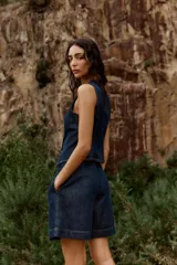 Shorts de denim azul oscuro, tiro alto, con pinzas delanteras y corte ancho. Incluye un cinturón fino marrón con hebilla de eslabones dorados.