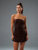 Vestido corto color marrón, con diseño strapless y ajuste entallado en la cintura con frunces laterales.