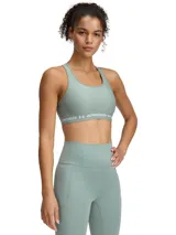 Top deportivo Under Armour de soporte medio, con diseño de espalda cruzada y banda elástica inferior con logo de la marca. Confeccionado en tejido HeatGear de doble capa, de secado rápido y alta transpirabilidad.