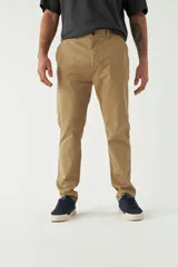 Pantalón chino de hombre en gabardina color camel, de calce regular, con cierre y bolsillos.