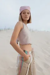 Pantalón de lino a rayas horizontales en tonos naranja, rosa y gris.