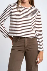 Remera de manga larga ajustada al cuerpo, con cuello redondo. Presenta un patrón de rayas horizontales anchas en color blanco y marrón oscuro.