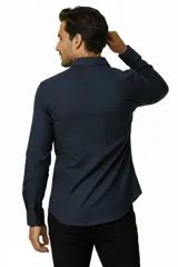 Camisa blanca de algodón, de corte slim fit, con cuello camisero, manga larga y cierre frontal de botones.