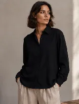 Camisa de diseño clásico con cuello camisero, mangas largas con puños abotonados y cierre frontal de botones.