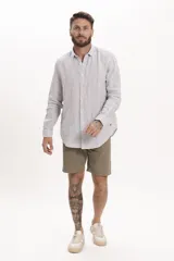 Camisa de lino de manga larga con diseño de rayas verticales finas, cuello clásico y cierre frontal abotonado.