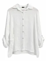 Camisa de lino color blanco, con cuello clásico, cierre frontal de botones, mangas largas con puños ajustables y bolsillos aplicados en el frente.