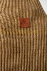 Capita de punto acanalado en color beige, con cuello alto y diseño abierto en los laterales.