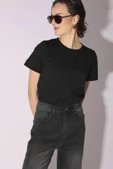 Pantalón de jean gris oscuro de corte acampanado, con tachas metálicas plateadas en los laterales.