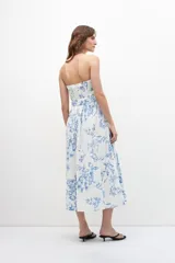 Vestido midi strapless con estampa floral azul sobre fondo blanco, con cinturón.