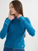 Polera básica de algodón en tejido rib, color turquesa, de manga larga, con hombreras y detalles de pespuntes en color contrastante en las terminaciones y el cuello.