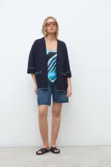 Kimono abierto de tejido de punto azul marino, con mangas tres cuartos y bolsillos frontales con detalles en hilo turquesa.