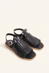 Sandalia plateada de cuero con tiras entretejidas, hebilla lateral y taco bajo.