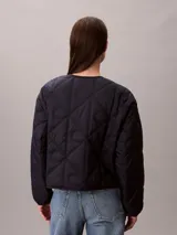 Campera acolchada ligera Calvin Klein de color azul marino, con cuello redondo, diseño acolchado con emblema CK integral, cierre frontal con botones a presión y manga larga de corte regular.