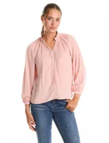 Blusa de gasa con plisado soleil, cuello a la base fruncido con escote en V regulable mediante lazos, y mangas largas abullonadas con puños sastreros.