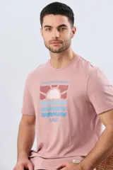 Remera blanca de manga corta y cuello redondo, con estampa frontal inspirada en el mar y atardeceres de verano con la inscripción 'Travel. Beach. Repeat.' y 'Legacy'.