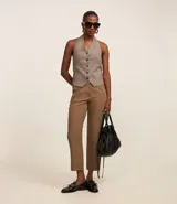 Pantalón zanahoria de sastrería color blanco, con cintura alta, trabillas y botón contrastante.