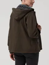 Campera de algodón color verde militar con capucha, cierre frontal con botones a presión y bolsillos delanteros con detalles de tejido aguayo multicolor. Presenta puños elásticos y cordón de ajuste en la capucha.
