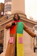 Tapado largo de paño con diseño colorblock en tonos tostado, amarillo, verde, naranja, rojo y rosa, con bolsillos aplicados.