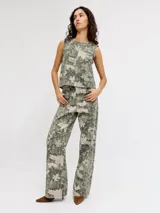 Pantalón de tiro alto, corte recto y amplio, confeccionado en sarga resistente con un estampado all-over camuflado en tonos verde militar y beige, con líneas verticales de pespuntes claros. Cuenta con cierre de cremallera y bolsillos delanteros y traseros.
