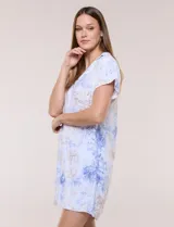 Vestido corto de lino color celeste con cuello camisero, escote en V, mangas cortas, bolsillos laterales invisibles y silueta holgada.