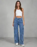 Jean de tiro medio con corte wide leg, confeccionado en denim azul. Presenta un diseño distintivo con apliques en forma de estrella con bordes deshilachados y bolsillos laterales tipo cargo.