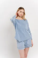 Remera manga larga color rosa con bolsillo en el pecho y corte irregular en el ruedo.