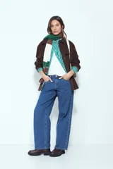 Jean de corte recto y silueta relajada, confeccionado en denim azul. Presenta una hilera de tachas metálicas decorativas a lo largo de los laterales de ambas piernas.