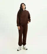 Pantalón jogger de mujer confeccionado en tejido fleece de algodón y poliéster. Presenta un corte holgado con cintura elástica y puños ajustados en el bajo.