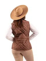 Chaleco acolchado color marrón, con cuello alto y cierre frontal. Presenta un patrón de costura diamante (capitoné) y un bolsillo horizontal con cierre en la espalda.