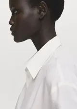 Camisa de lyocell color blanco, con cuello camisero, manga larga con puños abotonados, diseño recto y cierre frontal con botones ocultos.