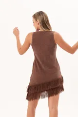 Vestido corto sin mangas de punto color marrón con sutil brillo, corte recto y dobladillo asimétrico adornado con flecos largos.