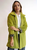 Tapado negro de piel sintética con cuello solapa y mangas largas. El forro interior de las mangas tiene un estampado animal print.