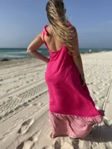Vestido largo de fibrana fucsia con volado rosa en el ruedo y tiras finas que se atan en los hombros.