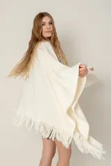 Ruana de lana color beige, tejida en punto acanalado con terminación de flecos en los bordes.